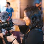 smiling woman holding black dslr camera